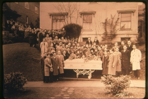 Men and women standing behind coffin outside building (Maryknoll) (ddr-densho-330-22)