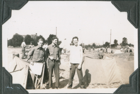Three men standing by tents (ddr-ajah-2-264)