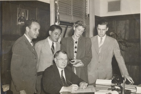 John H. Wilson signing a document while others look on (ddr-njpa-2-908)