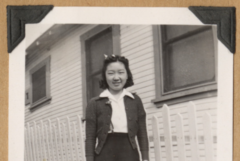 Girl standing by a picket fence (ddr-densho-542-215)