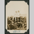 two girls on wood pile (ddr-densho-378-552)