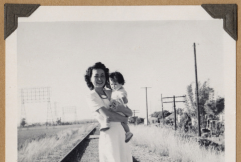 Woman holding a baby on railroad tracks (ddr-densho-542-348)