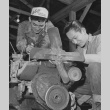 George Baba and Tokiji Umeda overhauling a truck loader in motor pool repair section at Rohwer incarceration camp (ddr-csujad-14-24)
