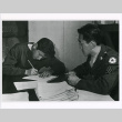 Young Nisei man completing questionnaire before enlisting (ddr-densho-122-755)