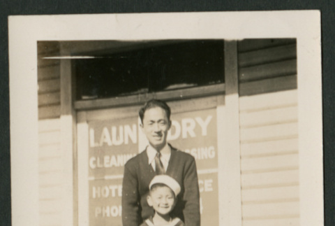 Man and child in front of dry cleaners (ddr-densho-359-125)