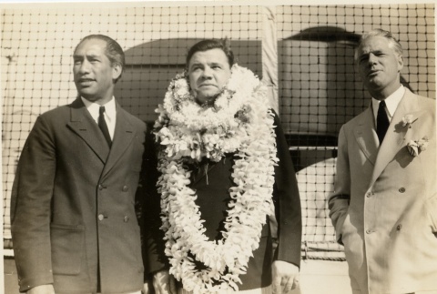 Babe Ruth wearing leis, standing with two men (ddr-njpa-1-1402)