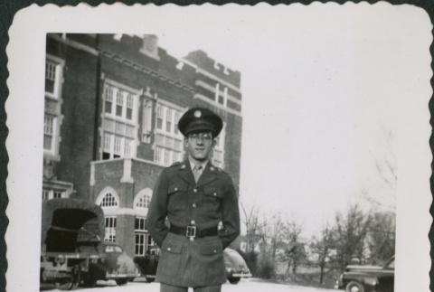 Man standing outside building, cars in background (ddr-densho-434-483)