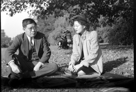 Tomoyuki Nozawa and Tomoye (Nozawa) Takahashi seated on a blanket in a park (ddr-densho-426-1739)
