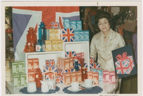 Tomoye Takahashi standing by display of British themed products (ddr-densho-426-1091)