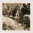 Tomoye (Nozawa) Takahashi standing in garden (ddr-densho-426-2117)