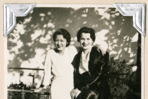 Two women sitting on fence (ddr-densho-383-24)