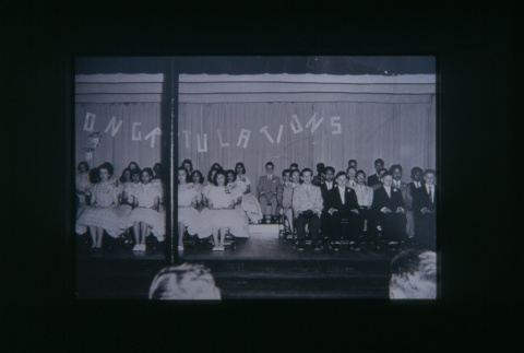 (Slide) - Image of group of boys and girls seated on a stage (ddr-densho-330-141-master-fdb9218d03)