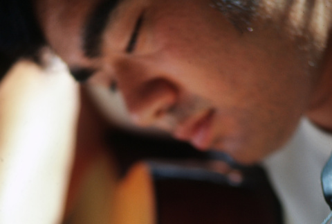 Ted Hasegawa playing guitar at morning watch (ddr-densho-336-1318)