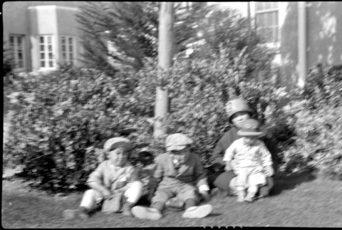 Three children and one woman sit on the ground (ddr-densho-480-7)