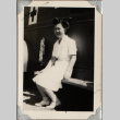 Woman sitting on bench by medical vehicle (ddr-densho-587-63)