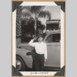 Boy saluting by a car (ddr-densho-542-207)