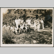 Group of men and women on grassy hill by trees (ddr-densho-483-565)