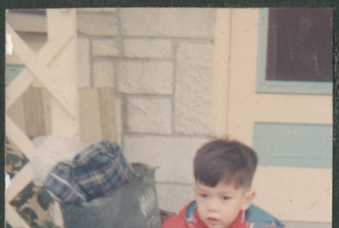 Boy with teddy bear sitting on suitcase (ddr-densho-523-420)