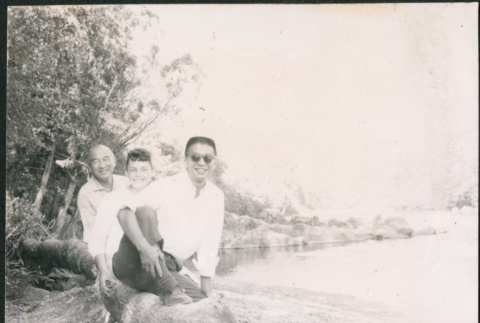 Chester Sakura Sr., with man and woman sitting on log (ddr-densho-523-335)