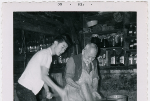 John Shigaki and Kakuzo Kawakami pounding mochi (ddr-densho-456-8)
