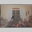 Chester and Agnes Sakura with man by Christmas tree holding presents (ddr-densho-523-468)