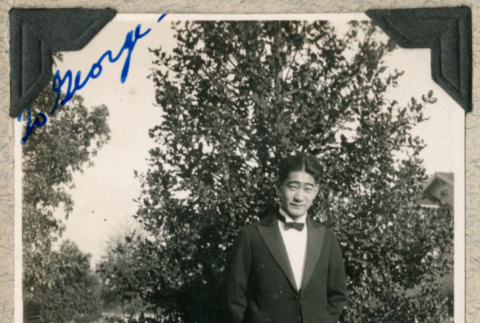 Bob Higashida in suit standing on lawn (ddr-densho-383-121)