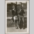 Man and woman sitting on wall, man holding camera (ddr-densho-466-65)