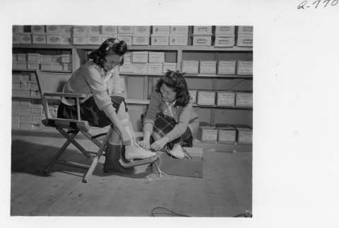Customer trying on ice skates at the Block 30 Community Store (ddr-fom-1-874)