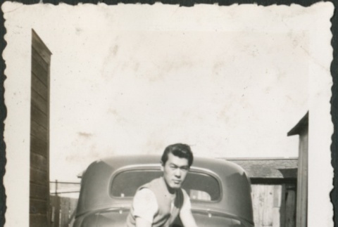 A man with his foot on a car (ddr-densho-298-89)