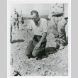 Japanese POW kneeling at a grave (ddr-densho-1007-281)