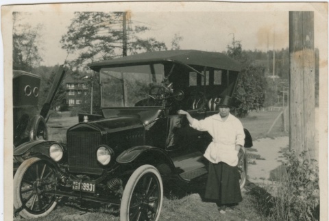 A woman standing next to a car (ddr-densho-321-543)