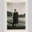 Henrietta Schoen posing in front of barracks (ddr-densho-223-9)