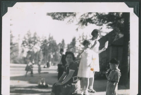 Photo of Mary Fukuyama sitting with three children eating popsicles (ddr-densho-483-952)
