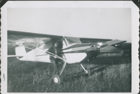 Man standing next to a propeller plane (ddr-densho-321-308)