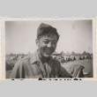 Laughing man standing with tents in background (ddr-densho-466-353)