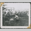 Group of men standing and sitting in patch of dug-up ground (ddr-densho-434-87)