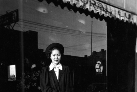 Yemiko Kono standing in front of florist shop (ddr-ajah-6-273)