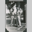 Two men standing by tree (ddr-ajah-2-551)
