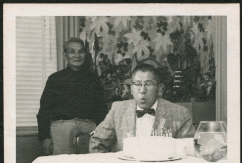 George Hirahara blowing out candles on a cake (ddr-densho-293-105)