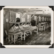Group seated at row of tables with sign for Housing (ddr-densho-587-80)