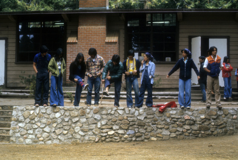 Campers preparing to jump off a rock wall (ddr-densho-336-765)