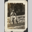Man seated on rock wall (ddr-densho-326-423)