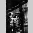 Tomoye (Nozawa) Takahashi and unknown man standing doorway of log house (ddr-densho-426-2020)