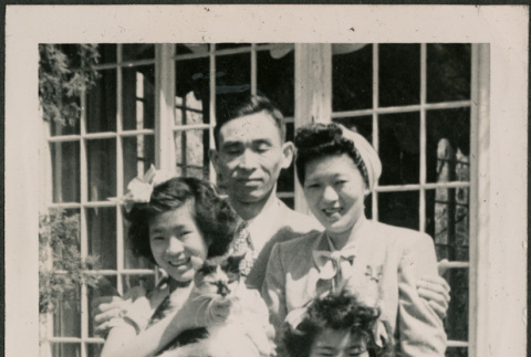 Family photo with man, woman and two girls, one holding a cat (ddr-densho-316-421)
