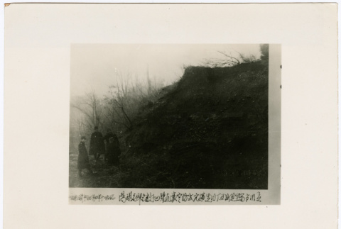 Four men stand next to a destroyed bomb shelter (ddr-densho-381-106)