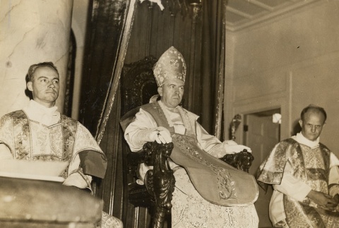 James Sweeney and two priests seated on altar, wearing vestments (ddr-njpa-2-936)