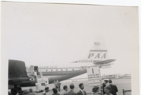 Group waiting at airport, PanAm airplane in background (ddr-densho-426-866)