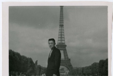 Photo of Yuichi 'Lou' Sumi standing by Eiffel Tower (ddr-densho-399-19)