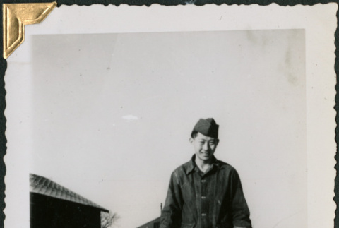Man standing in field holding papers(?) (ddr-densho-434-330)