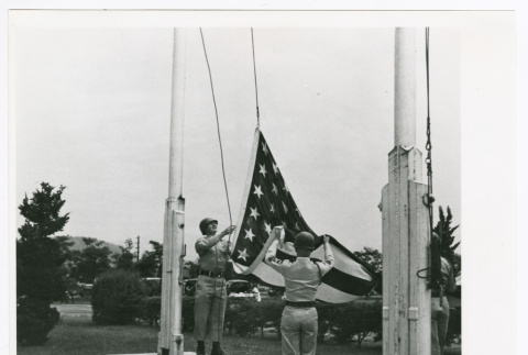 American flag lowered at the closing of Camp Younghans (ddr-densho-1007-125)